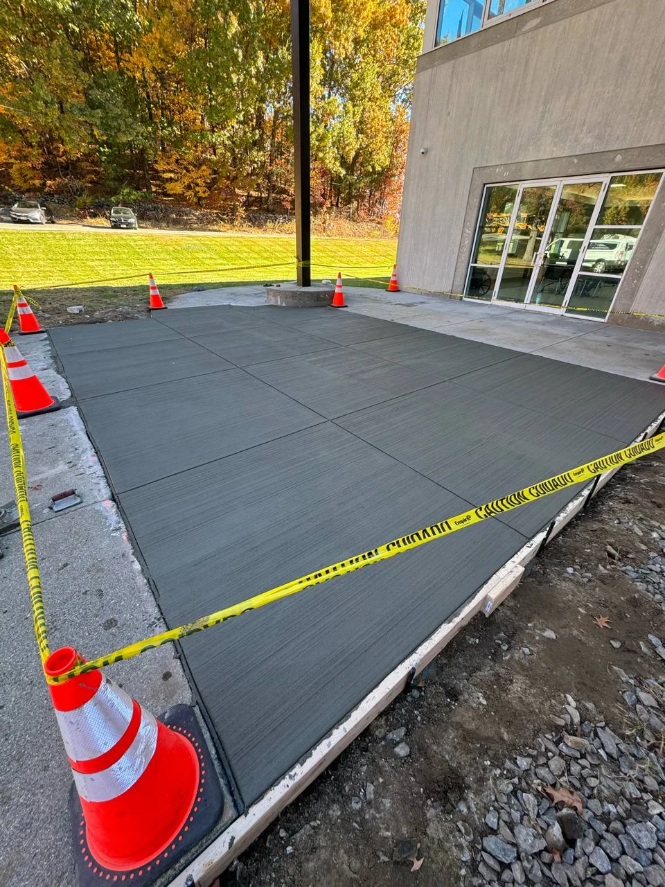 Freshly finished broom-textured concrete at a commercial entrance, poured by Mud Brothers