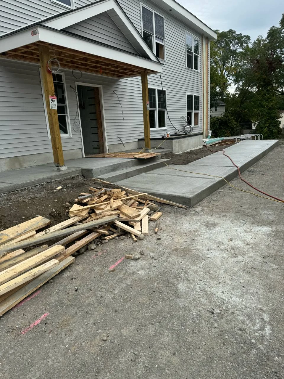 Concrete entry steps and a new walkway alongside a residential building